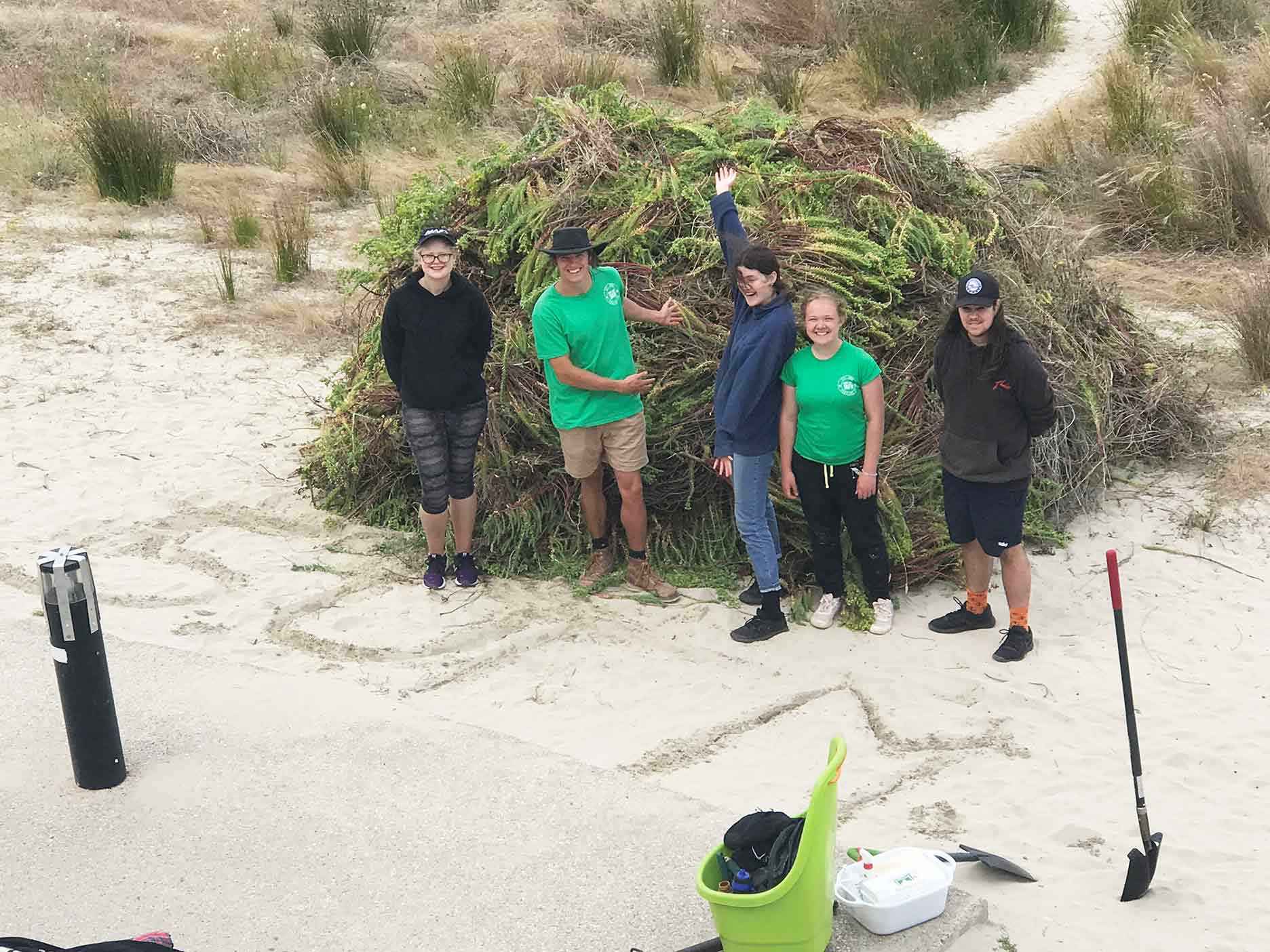 Participants from the Scripture Union Family Mission and PCCI member Nikolaus Oakley beside an enormous pile of hand weeded sea spurge that was removed in January 2021. 