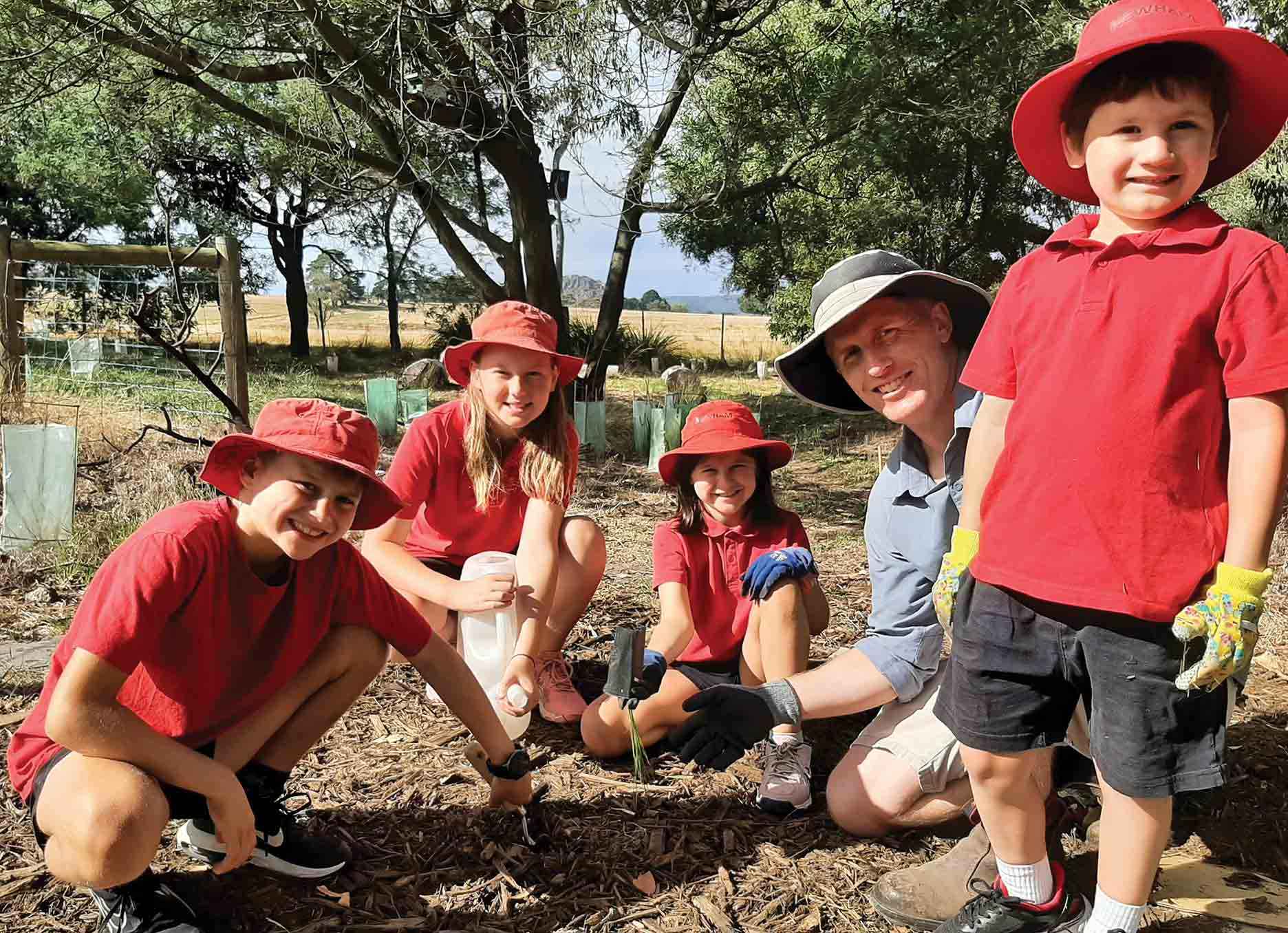 Foundation to year 6 students from Newham Primary School with a parent planting out the Biodiversity Learning Hub on the school grounds. 