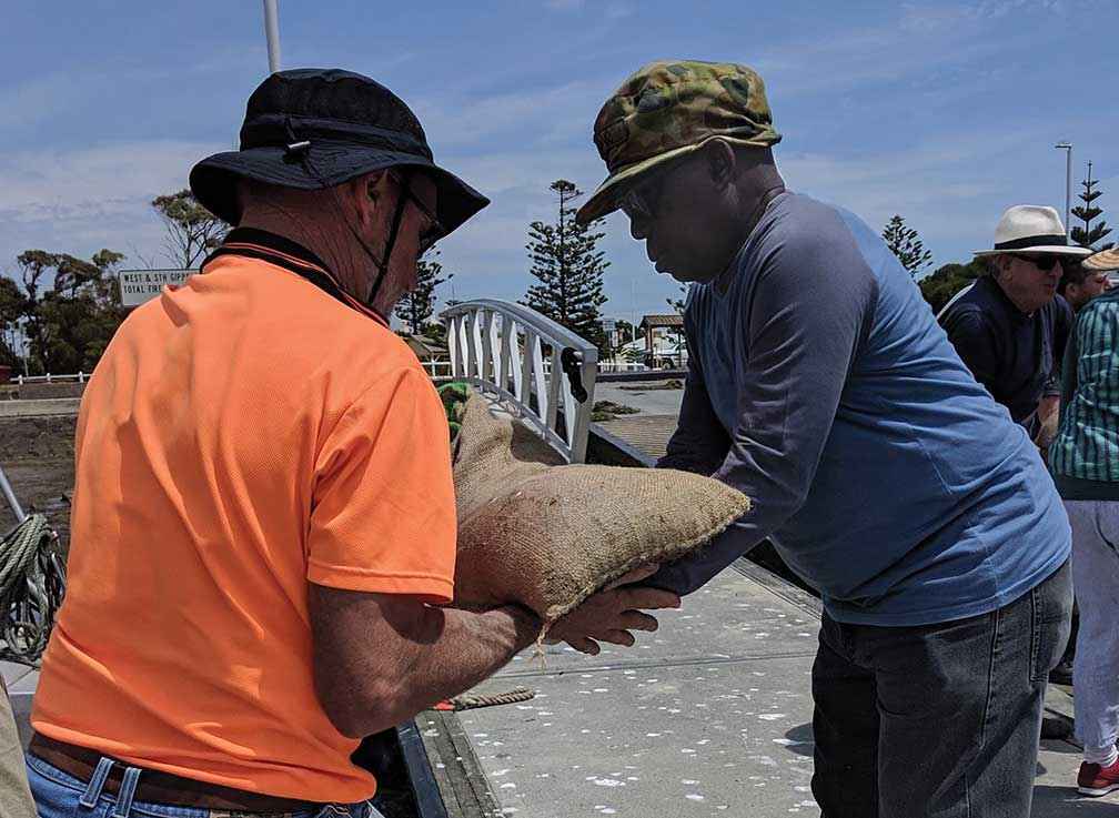 Volunteers quickly deliver the seed bags to boats where they are taken six kilometres out to sea. 