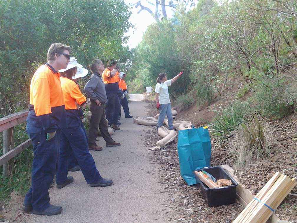 Ann Robson from BULG briefs members of the Green Army and Federation Training VCAL students on installing silt worms (hessian tubes filled with rice husks) to stop erosion while plants grow on the steep slopes of the south bank of the Mitchell River at the Port of Bairnsdale in 2016.