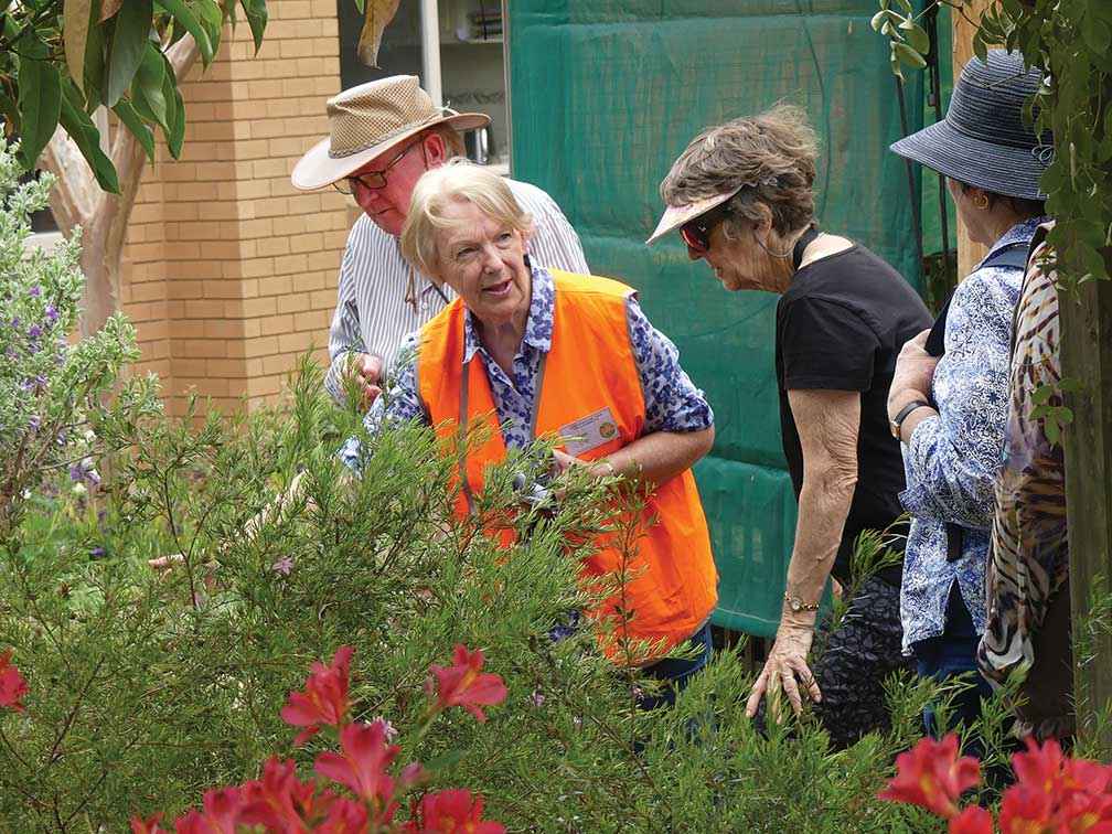 Volunteer Pam Ilott (in high vis) leads a tour of her habitat garden in 2019. 