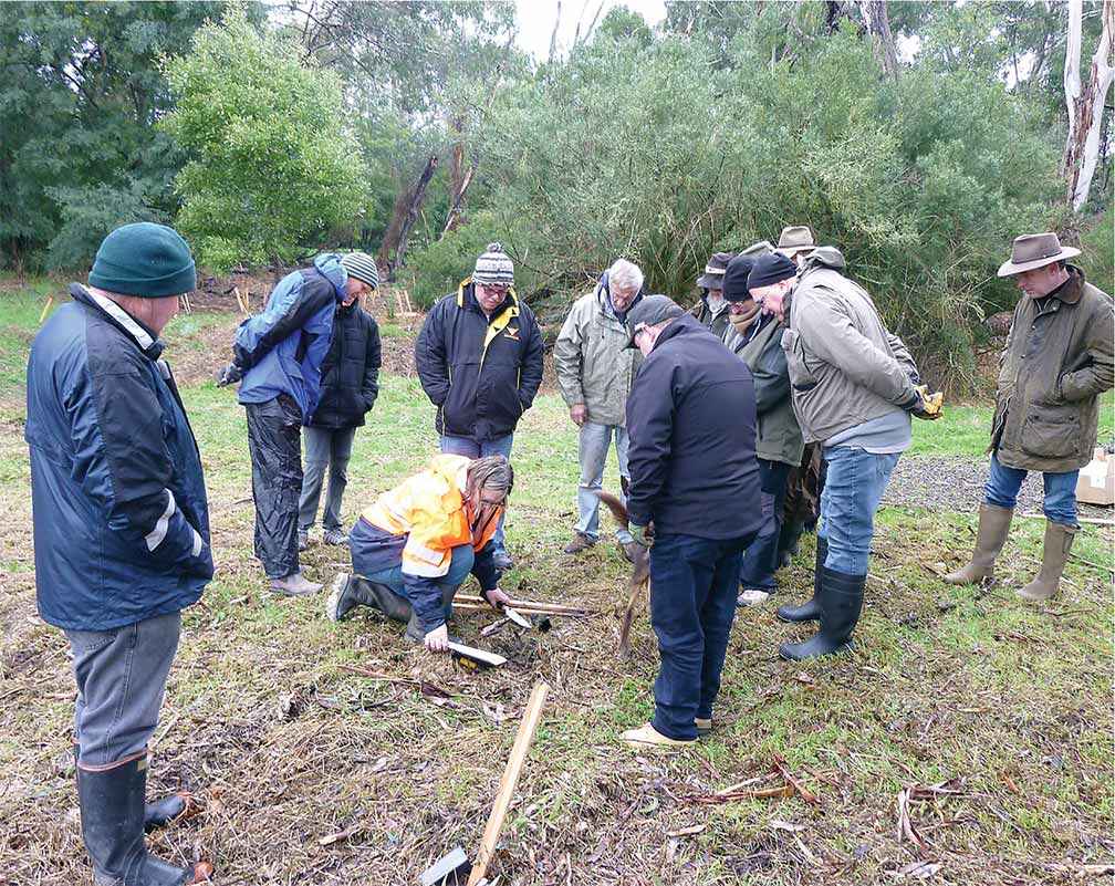 Sue Kosch from the Goulburn Broken CMA demonstrates planting techniques to members of the Victorian Fly-Fishers’ Association at Taggerty.